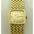 A lady's 18ct gold Omega wristwatch, the square gold face with baton numerals, on a woven gold strap... 