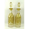 A pair of Bohemian flashed glass decanters, encased amber, decorated with fruiting vines, 36cm.