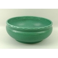 A Susie Cooper studio pottery bowl, in viridian green gorund with cut facet rim with teardrop band t... 