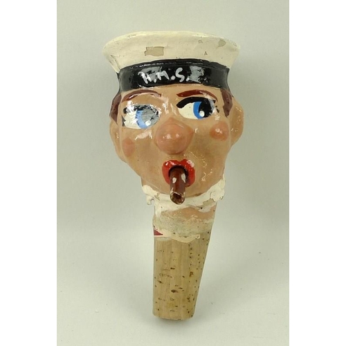 708 - A 1930's papier mache bottle stop of a H.M.S sailor with cigar, on a cork stopper, 12cm.