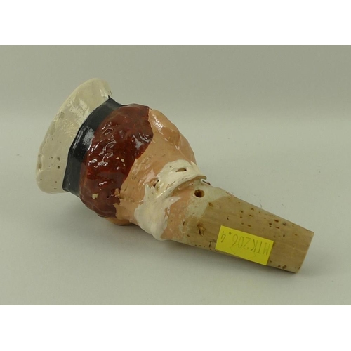 708 - A 1930's papier mache bottle stop of a H.M.S sailor with cigar, on a cork stopper, 12cm.