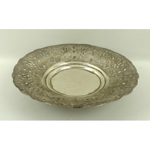 722 - An Egyptian white metal dish, hand engraved and pierced on three feet, with Egyptian silver marks, 2... 