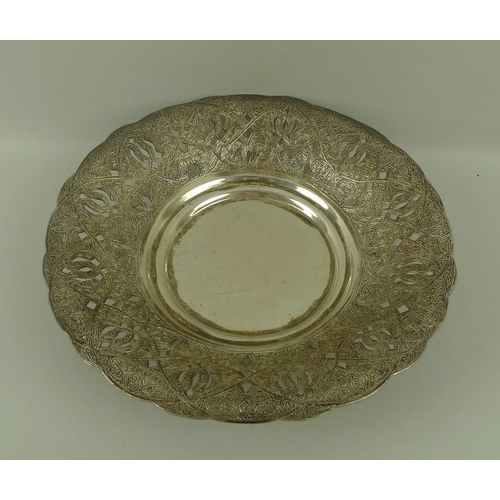 722 - An Egyptian white metal dish, hand engraved and pierced on three feet, with Egyptian silver marks, 2... 