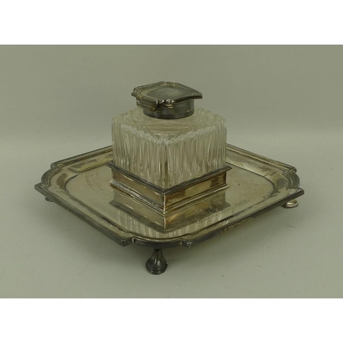 737 - A silver desk inkwell on stand, the cut glass inkwell of square form with silver lid, the stand with... 