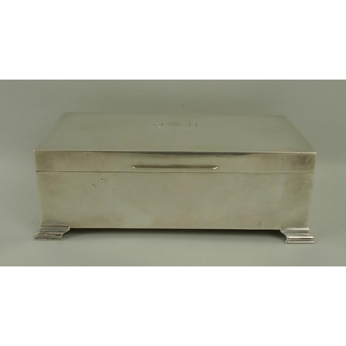 747 - A silver cigarette box, with stepped bracket feet and engine turned decoration, monogram engraved 'J... 