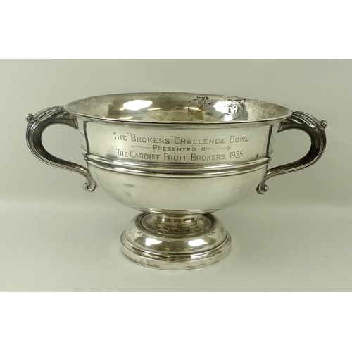 759 - A Walker and Hall silver trophy, of circular form with belted decoration, scroll handles and on a st... 