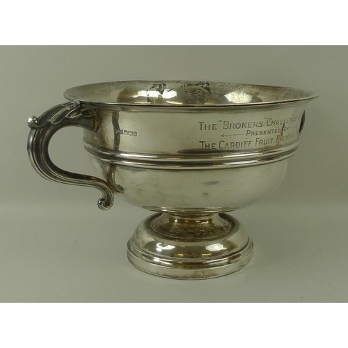 759 - A Walker and Hall silver trophy, of circular form with belted decoration, scroll handles and on a st... 