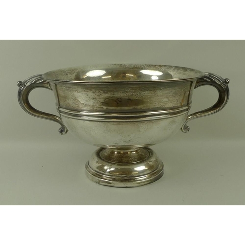 759 - A Walker and Hall silver trophy, of circular form with belted decoration, scroll handles and on a st... 