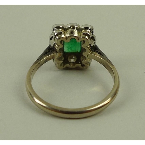 824 - An 18ct white gold, emerald and diamond ring, circa 1900, the central square cut emerald surrounded ... 