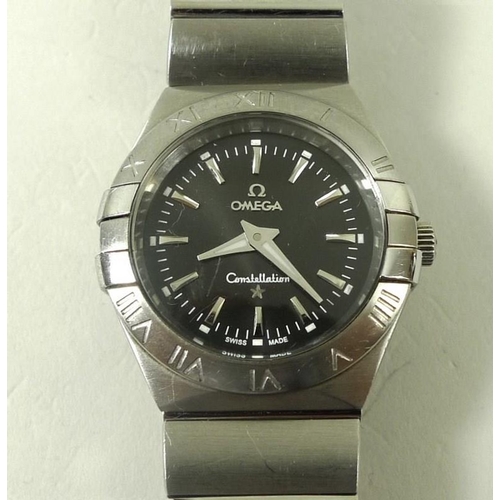 835 - An Omega Constellation wristwatch, with steel casing and wrist band, black face with batons, and Rom... 