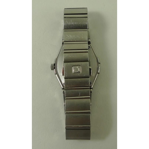 835 - An Omega Constellation wristwatch, with steel casing and wrist band, black face with batons, and Rom... 