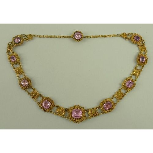 839 - A cannetille and pink topaz necklace, early 19th century, set with nine graduated stones divided by ... 