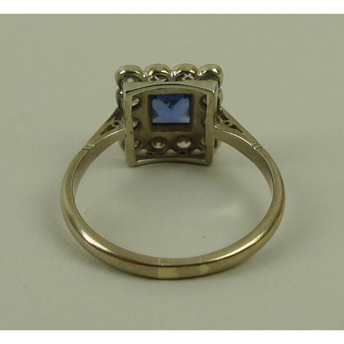 849 - An 18ct white gold, sapphire and diamond ring, circa 1900, the central square cut sapphire surrounde... 