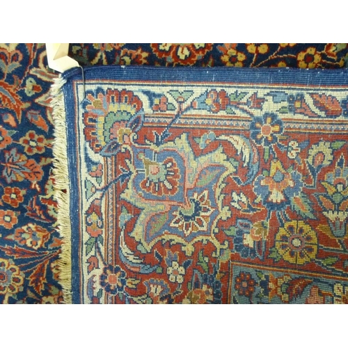 912 - A 19th century Persian wool rug, hand knotted in blues, reds and pinks, decorated with a central med... 