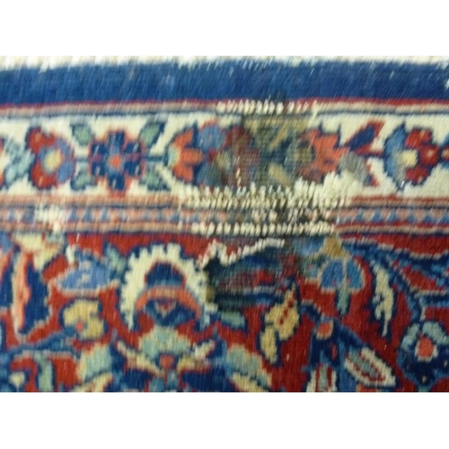 912 - A 19th century Persian wool rug, hand knotted in blues, reds and pinks, decorated with a central med... 