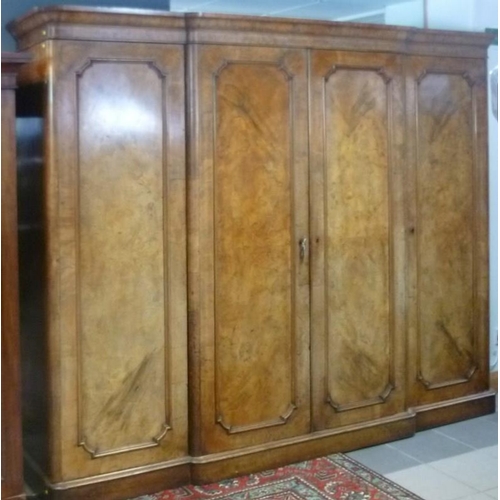 918 - A Victorian walnut break front compactum wardrobe, the central doors enclosing three slides above tw... 