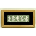A Wedgwood rectangular plaque depicting dancing girls on an olive green ground, 8 by 23cm.