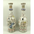 A pair of Japanese vases, late 19th century, of ovoid form, with long necks, each decorated with a f... 