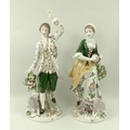 A pair of Sitzendorf figurines, modelled as a girl with a tambourine and sheep, and a dancing man wi... 