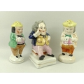 A Staffordshire ceramic figurine of a Dickens character, 14cm, and two Staffordshire Toby pepper sha... 