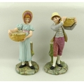 A pair of Royal Worcester blush ivory porcelain figurines, modelled as a boy and girl each carrying ... 