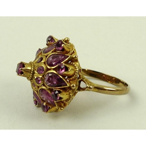 790 - A 14ct gold and pink sapphire dress ring, the ornate raised setting of a single stone surrounded by ... 