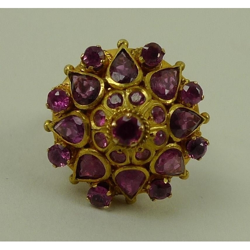 790 - A 14ct gold and pink sapphire dress ring, the ornate raised setting of a single stone surrounded by ... 