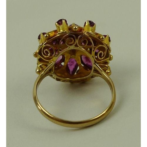 790 - A 14ct gold and pink sapphire dress ring, the ornate raised setting of a single stone surrounded by ... 