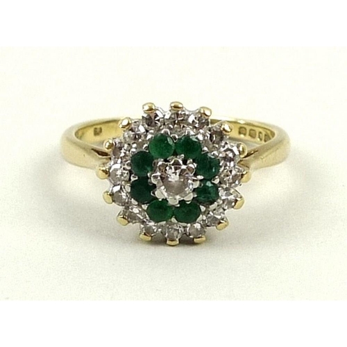 796 - An 18ct gold, diamond and emerald dress ring, the central diamond approximately 0.1ct surrounded by ... 