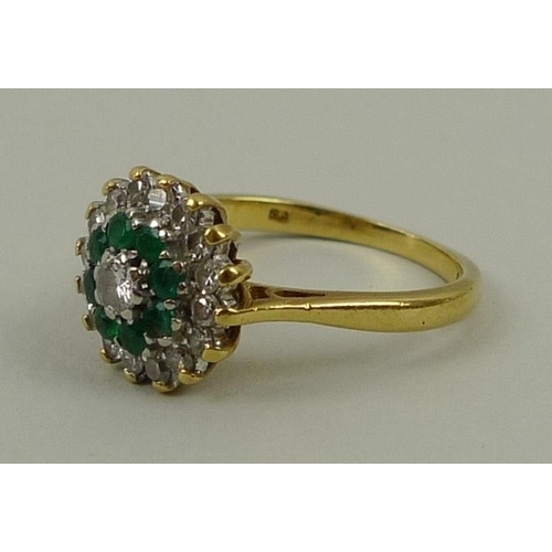 796 - An 18ct gold, diamond and emerald dress ring, the central diamond approximately 0.1ct surrounded by ... 