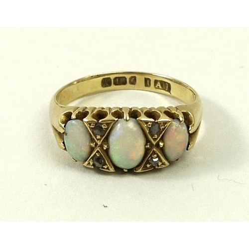 801 - An 18ct gold, opal and diamond ring, the three graduated oval cut opals divided by two pairs of chip... 