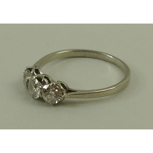 814 - A three stone diamond ring, approximate total 0.5ct, on a white metal band, size O.