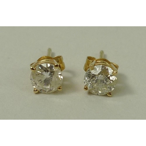 828 - A pair of 14ct gold and diamond ear studs, the brilliant cut diamonds each of approximately 0.5ct, 1... 