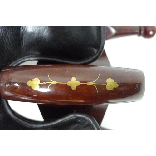 842 - A South East Asian hardwood camel saddle, with brass inlaid decoration and loose black leather seat ... 