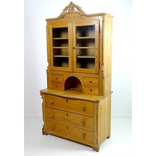 845 - A Continental pine dresser, with carved shaped cornice, twin glazed doors enclosing two shelves, fou... 