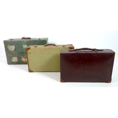 850 - A group of three vintage suitcases, comprising a tin suitcase, a leather case and a linen case with ... 