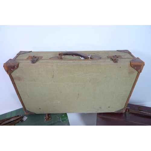 850 - A group of three vintage suitcases, comprising a tin suitcase, a leather case and a linen case with ... 