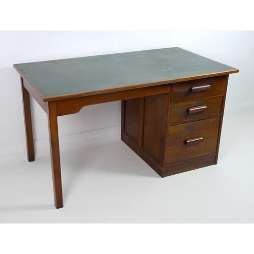 852 - A mid 20th century oak pedestal desk, with inset green surface, two shallow drawers and one filing d... 