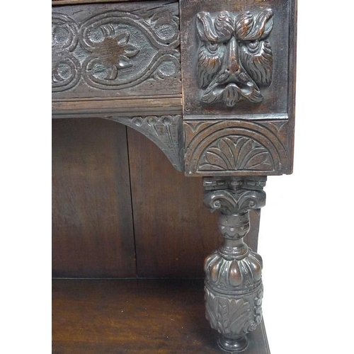 900 - A Victorian stained oak carved bookcase, with 17th century carved angel / cherub mask attached centr... 