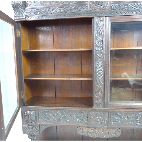 900 - A Victorian stained oak carved bookcase, with 17th century carved angel / cherub mask attached centr... 