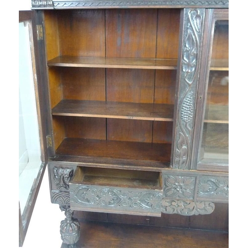 900 - A Victorian stained oak carved bookcase, with 17th century carved angel / cherub mask attached centr... 