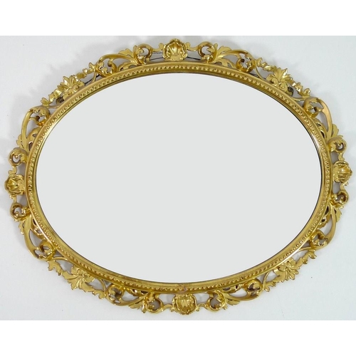 904A - An Italian style giltwood mirror, early 20th century, with oval bevelled plate, 50 by 40cm, 82 by 65... 