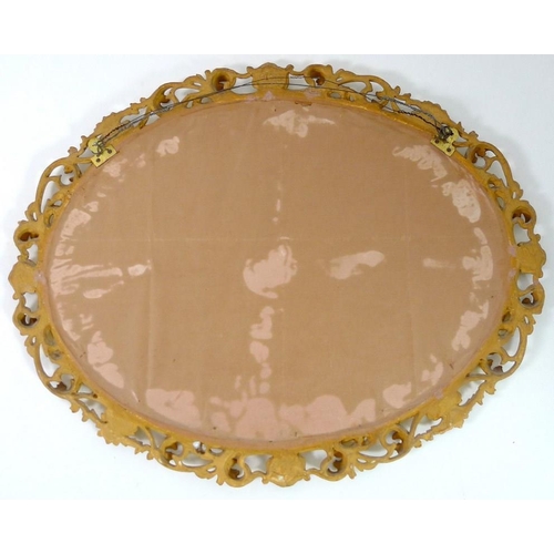 904A - An Italian style giltwood mirror, early 20th century, with oval bevelled plate, 50 by 40cm, 82 by 65... 