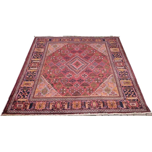 905A - A Mimeh rug, with red ground and geometric diamond decoration, 345 by 242cm.