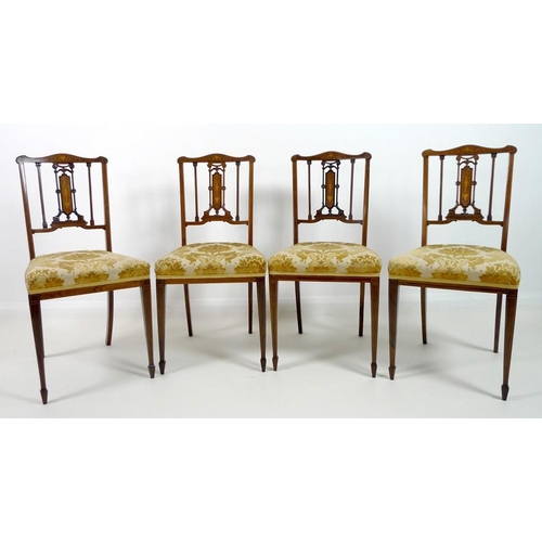 909 - Four Edwardian mahogany and marquetry inlaid salon chairs, the pierced splats intricately formed wit... 