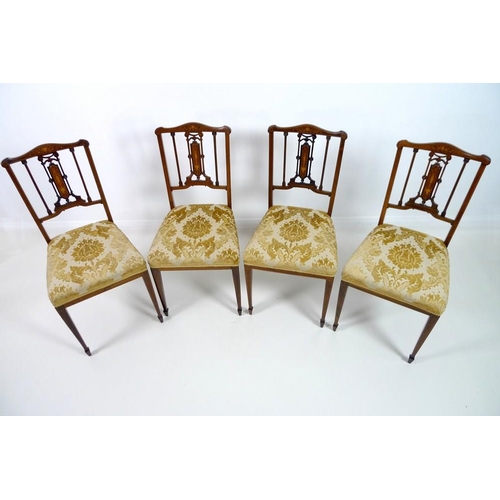 909 - Four Edwardian mahogany and marquetry inlaid salon chairs, the pierced splats intricately formed wit... 