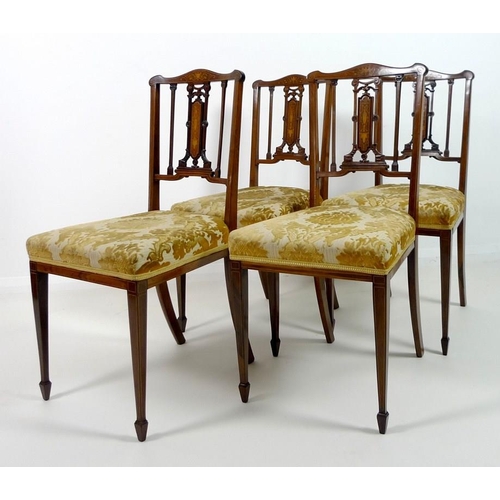 909 - Four Edwardian mahogany and marquetry inlaid salon chairs, the pierced splats intricately formed wit... 