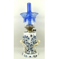 A Dresden blue and white paraffin lamp, circa 1890, the china base decorated with raised roses and a... 
