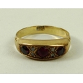 An 18ct gold three stone ring, set with three garnets divided by four small diamonds, size O, 3.4g.