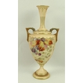 A Royal Worcester blush ivory porcelain twin handled vase, painted with autumn fruits and gilded wit... 